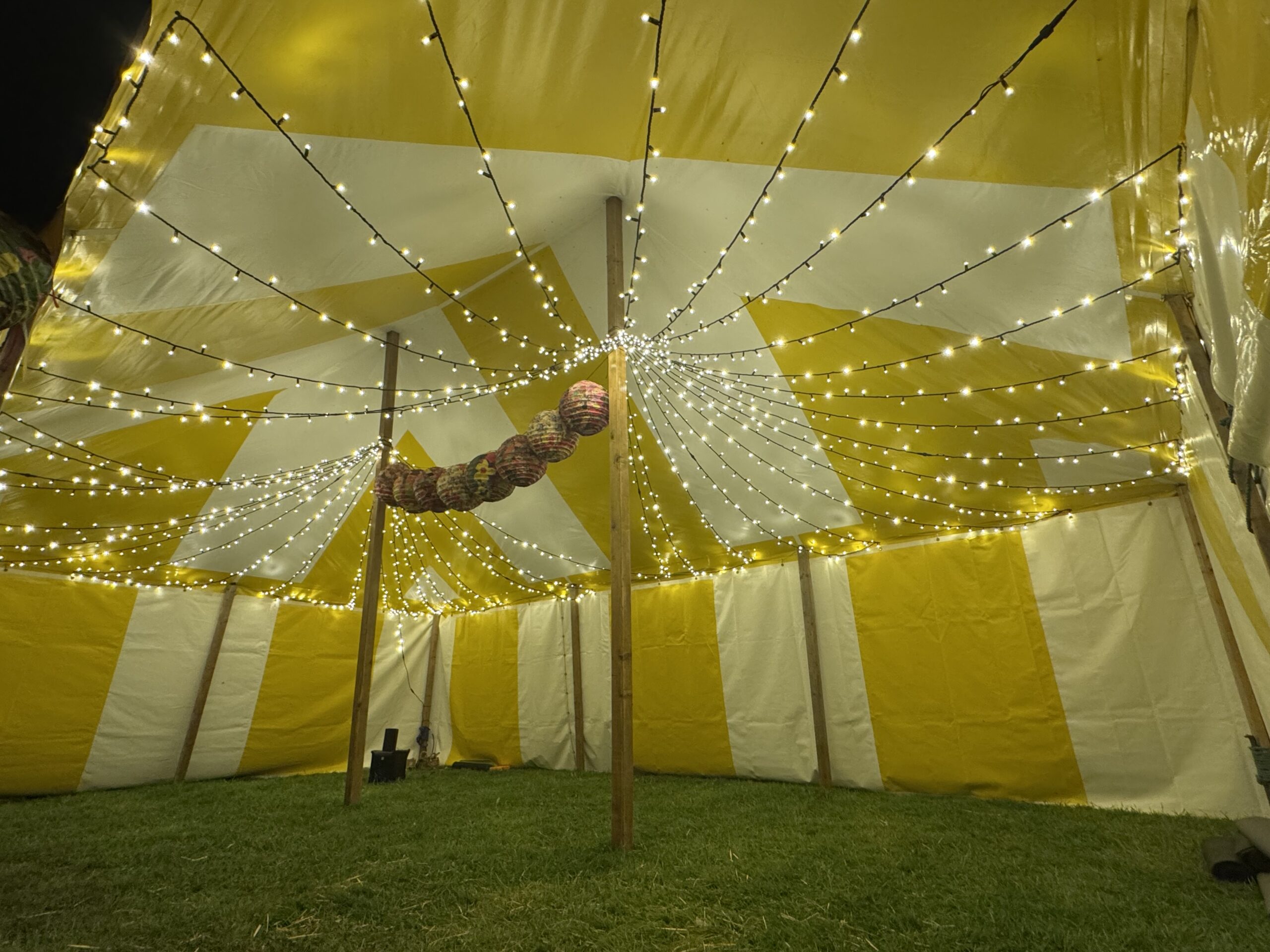 Fairy light installation creating atmospheric lighting inside a yoga and circus tent